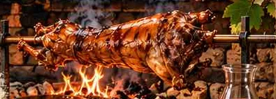 Lamb roasting on a spit next to an open fire